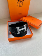 Dark leather Hermes belt with silver-toned H buckle on display