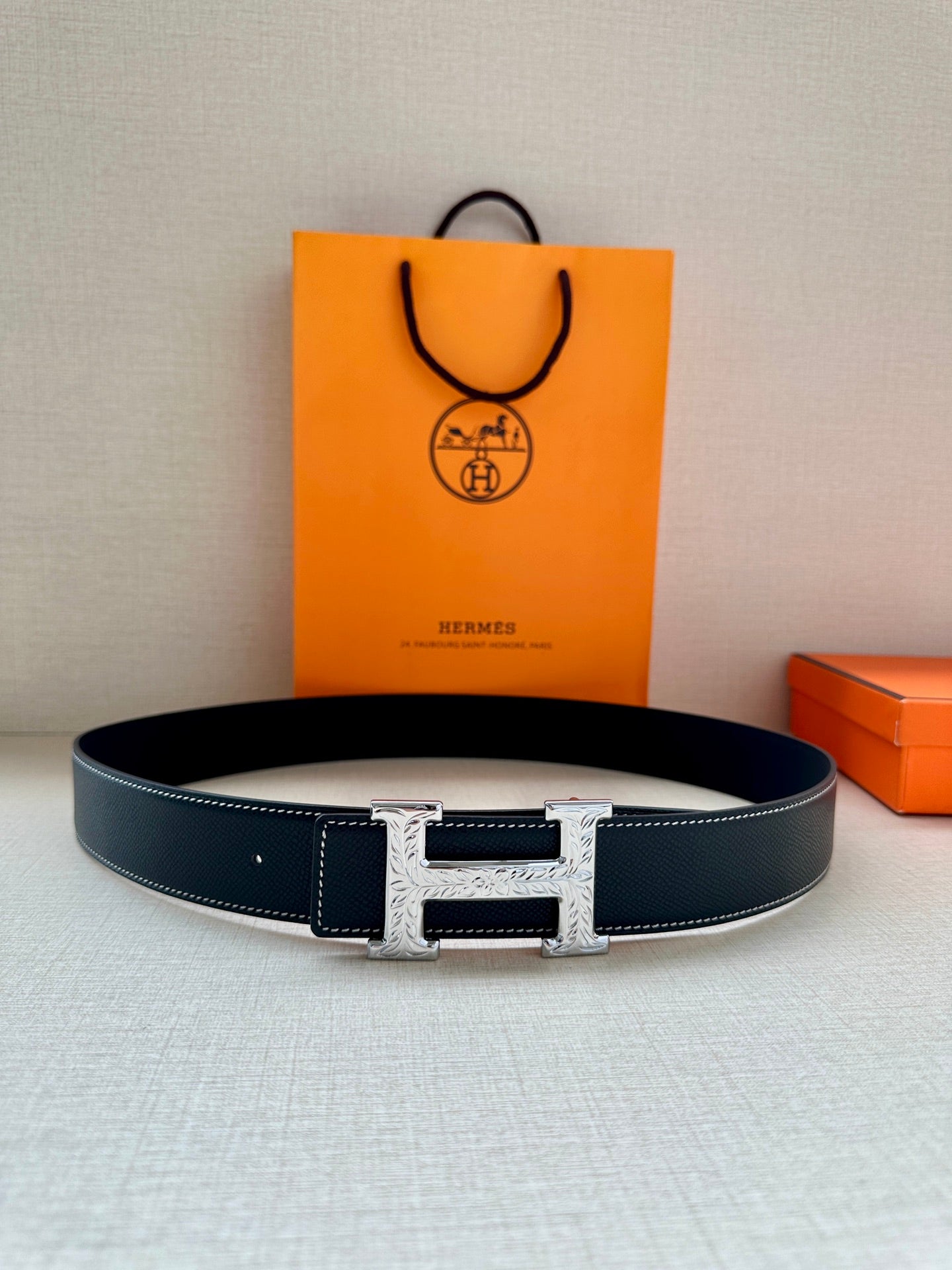 Hermes leather belt with dark strap and silver-toned H buckle