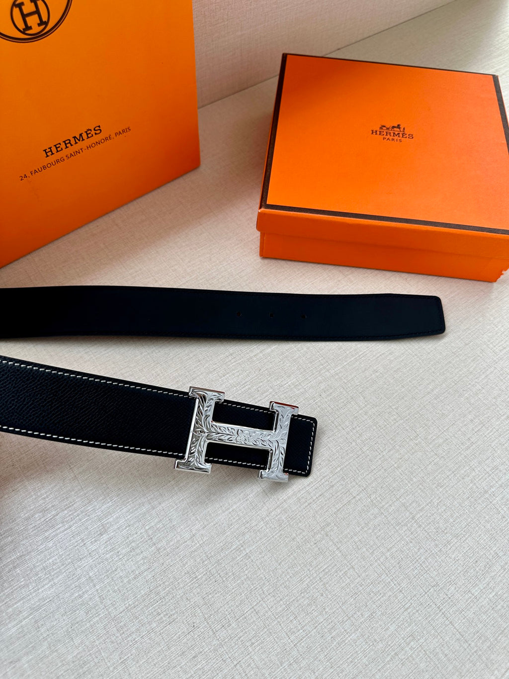 Dark leather belt strap with silver-toned H buckle detail