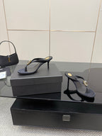 Women’s black high-heel thong sandals featuring a gold-toned jeweled toe detail.
