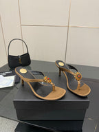 Thong heeled sandals with black straps, tan footbed, and jeweled flower detail