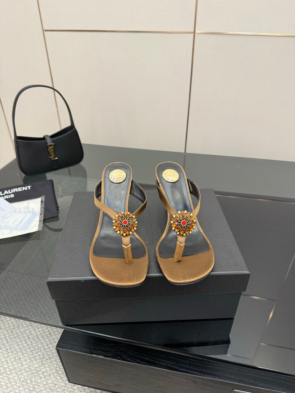 Thong heeled sandals with tan footbed, black toe straps, and colorful jewel flower