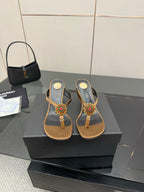 Thong heeled sandals with tan footbed, black toe straps, and colorful jewel flower