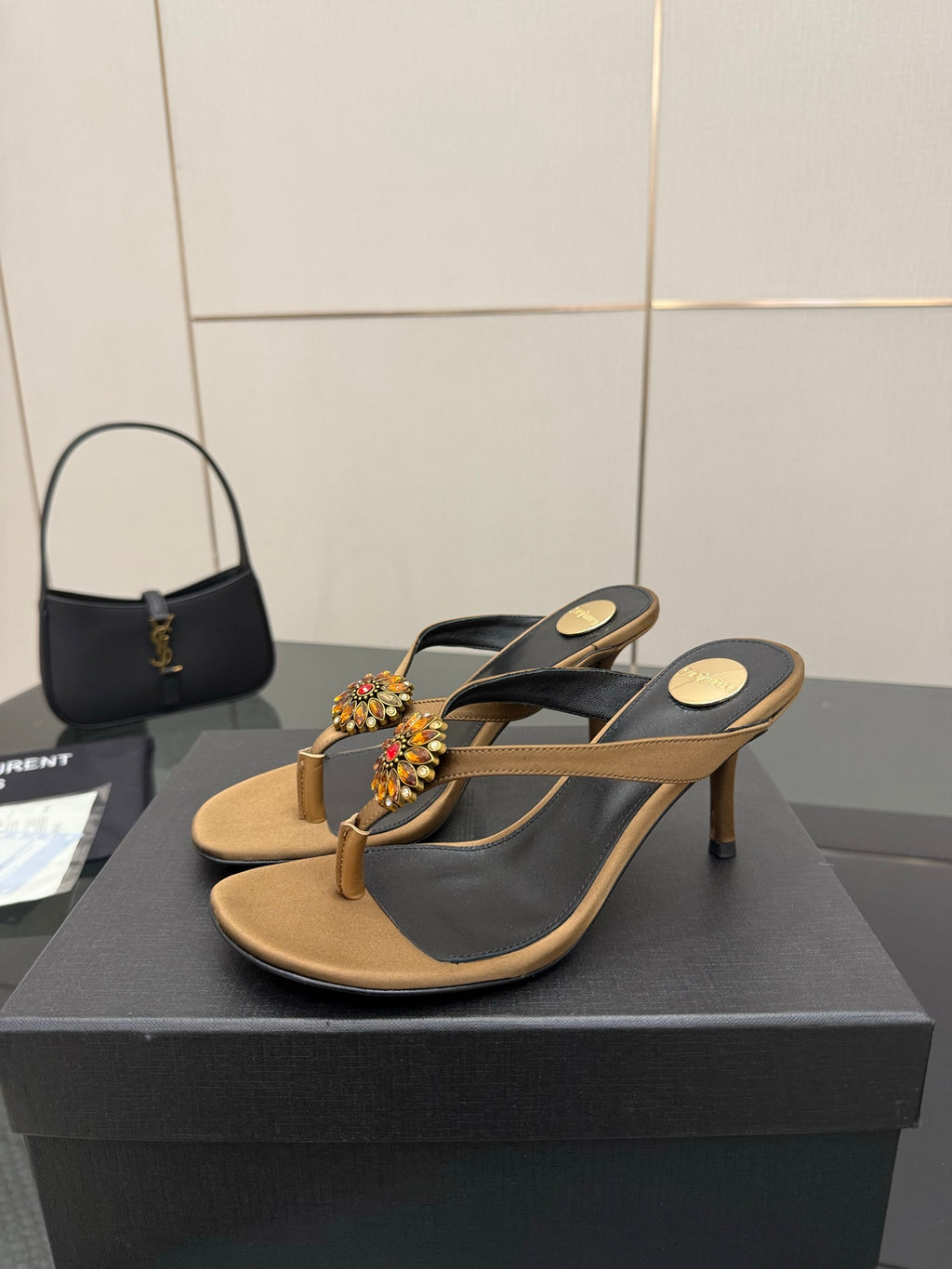 Pair of thong heeled sandals in tan and black with jeweled flower embellishments
