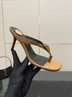 Thong heeled sandal close-up with tan sole, black interior, and jeweled flower