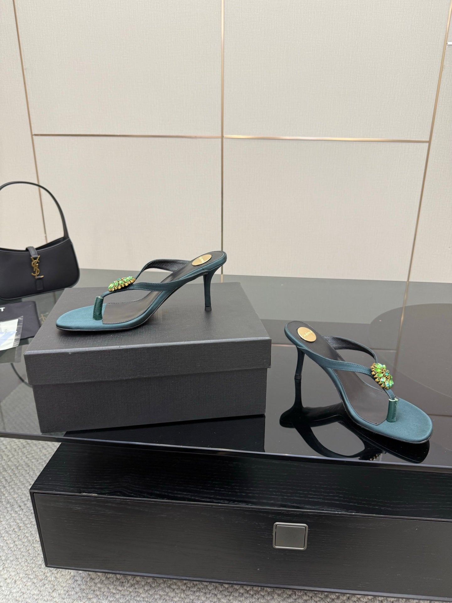 Women's teal heeled sandal and black heeled sandal on shoe boxes