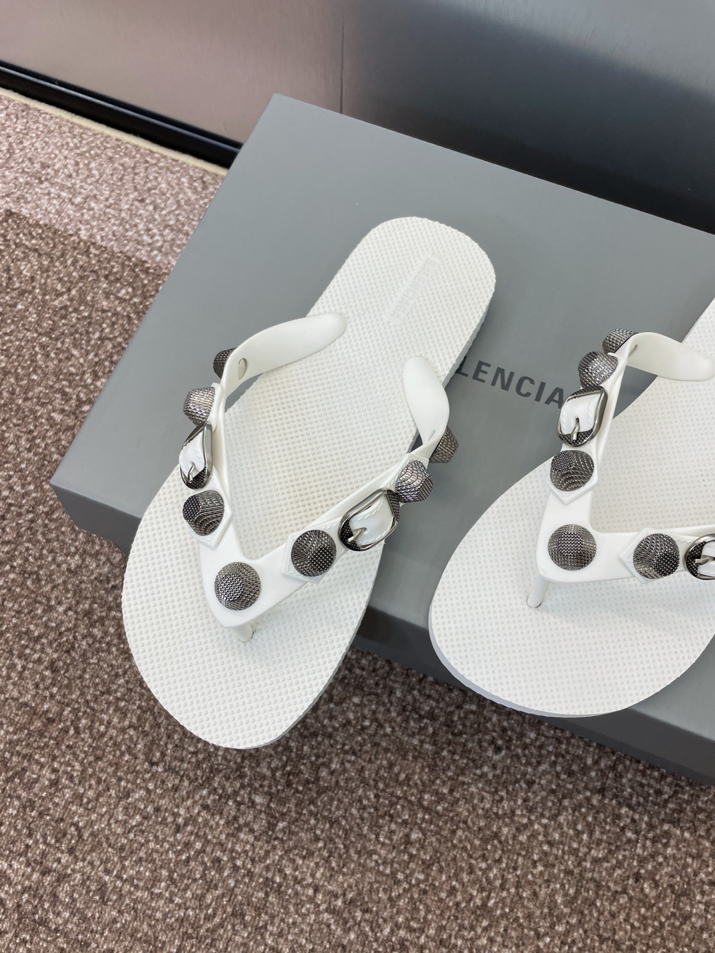 White thong sandals with round stud accents and silver-tone buckles
