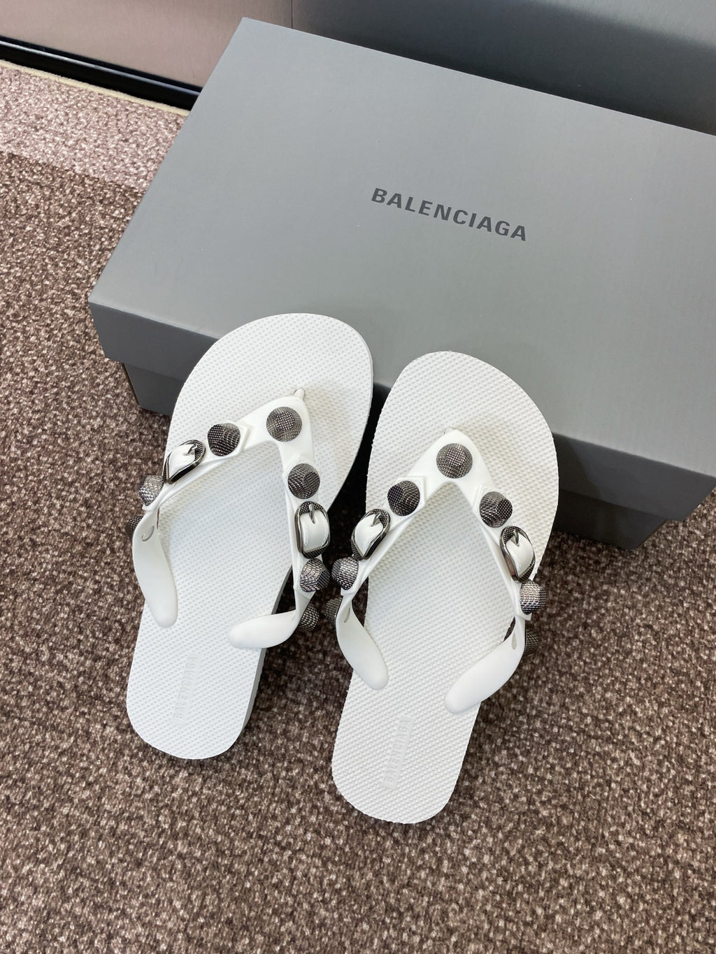 White thong sandals with studded straps and silver-tone buckle details