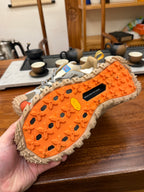 Shoe outsole with orange tread blocks and gray rubber lugs