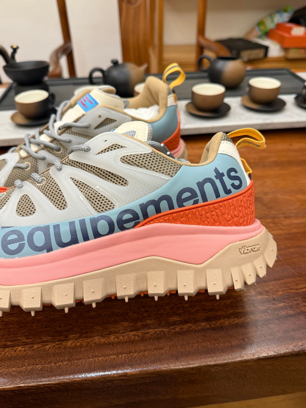 Light gray mesh sneakers with orange trim and pink sole, chunky traction tread