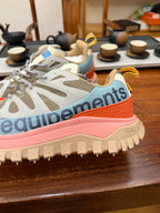Light gray mesh sneakers with orange trim and pink sole, chunky traction tread