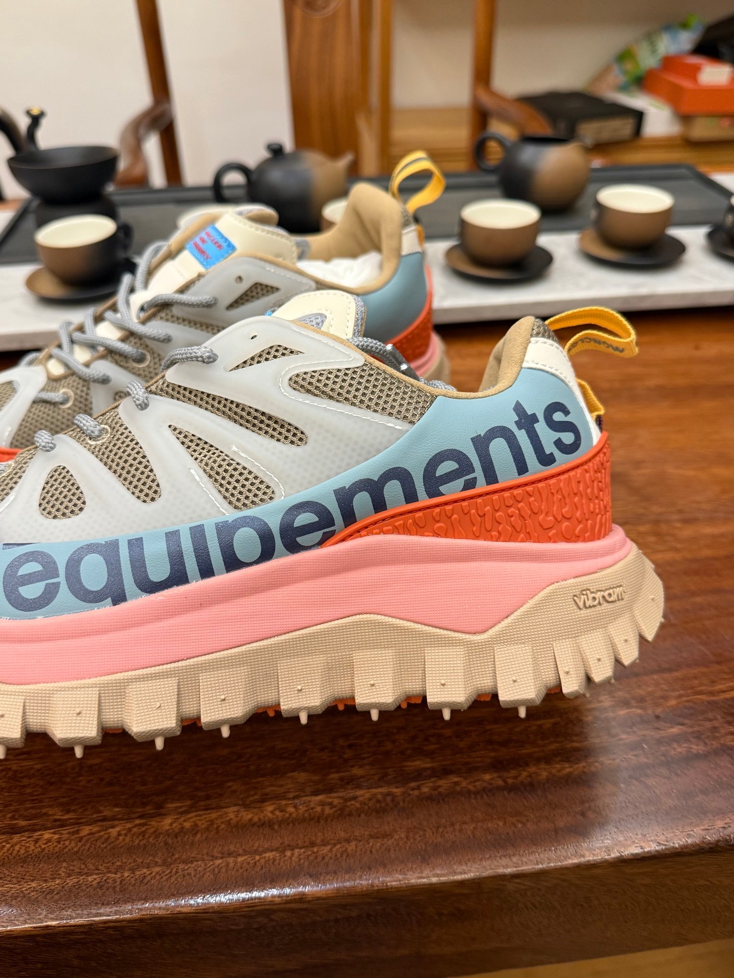 Light gray mesh sneakers with orange trim and pink sole, chunky traction tread