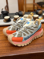 Light gray mesh sneakers with orange side panels and chunky tread sole