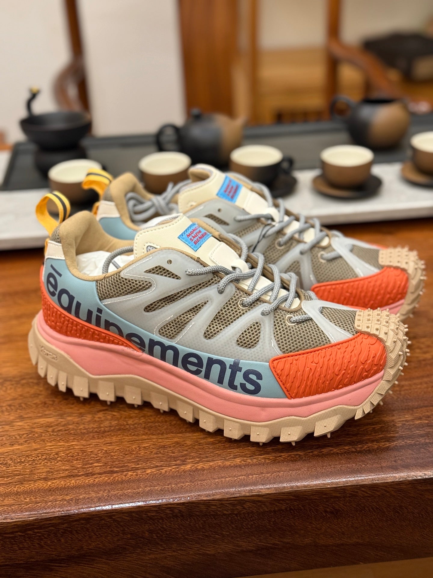 Light gray mesh sneakers with orange accents and pink midsole, lace-up