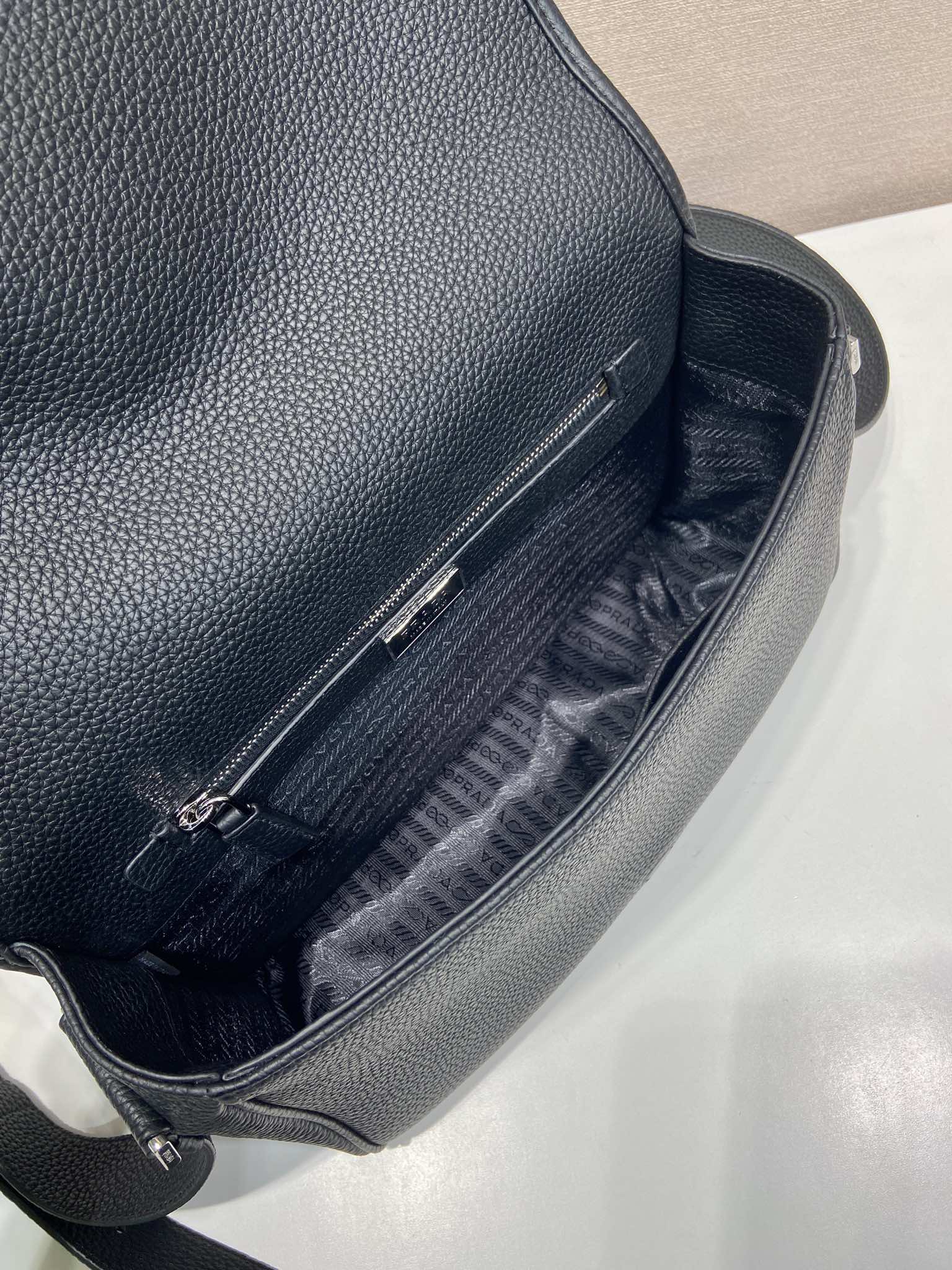Prada leather crossbody bag interior, black lining and zipper pocket close-up
