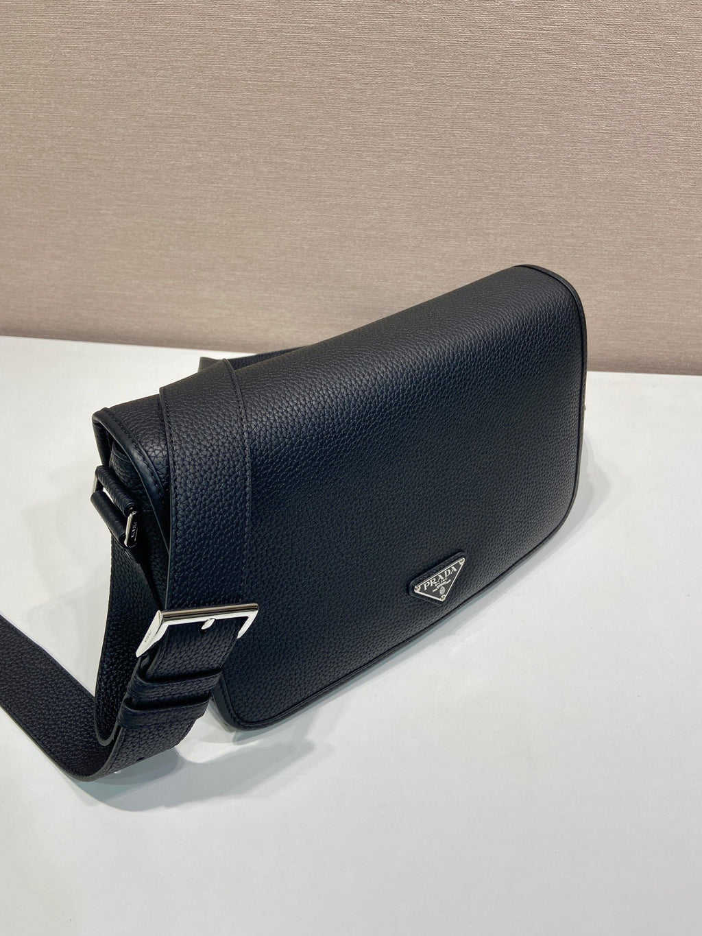 Prada leather crossbody bag, black, with silver buckle detail and triangle logo