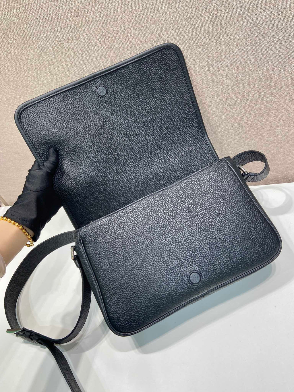 Prada leather crossbody bag open, black, with strap and two snap buttons