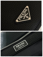 Prada zipper and logo label on black textured leather crossbody bag