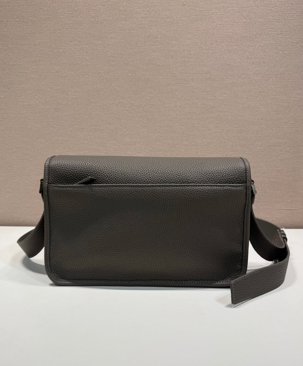 Prada leather crossbody bag with flap front, smooth grain texture, and side strap