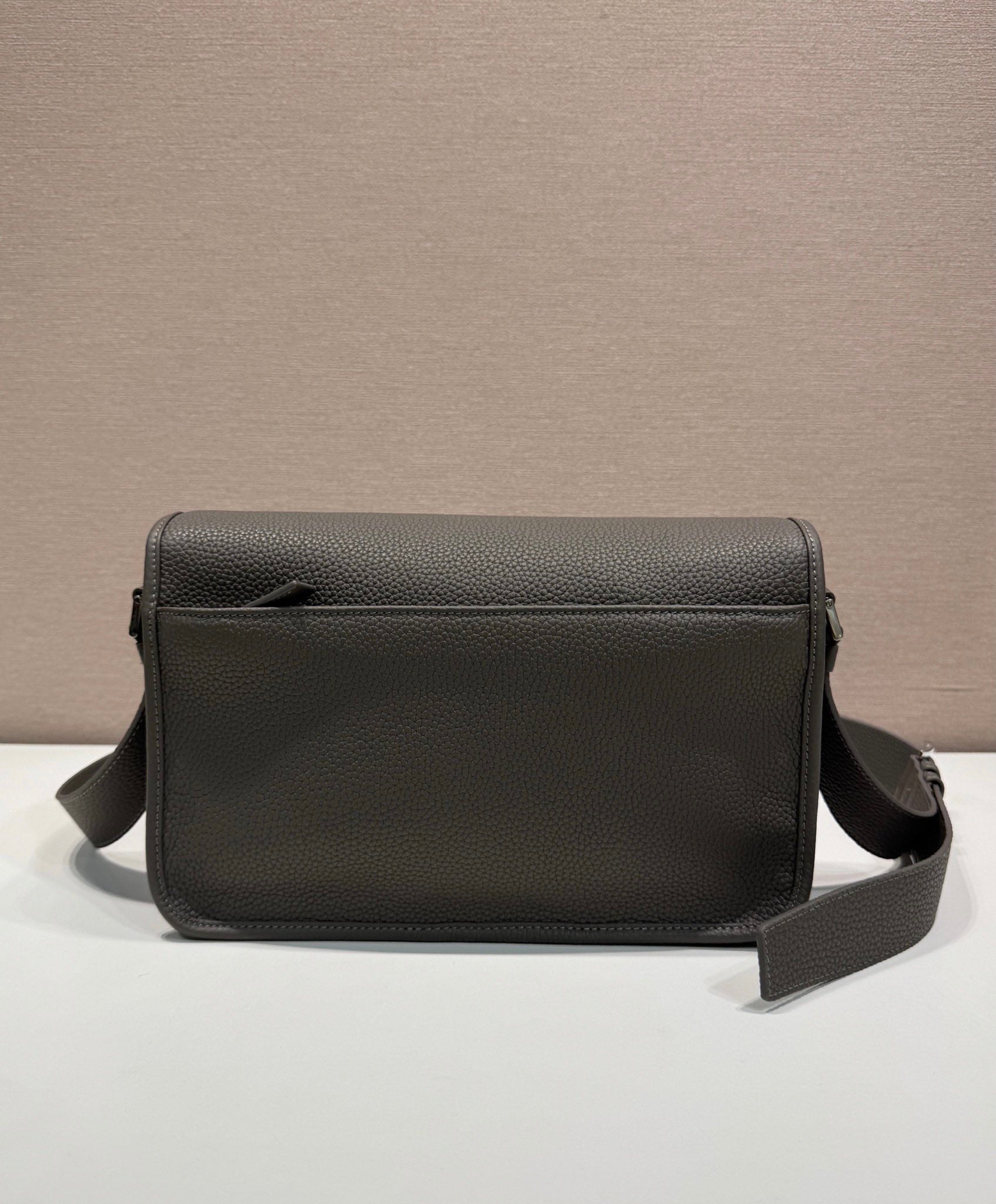 Prada leather crossbody bag with flap front, smooth grain texture, and side strap