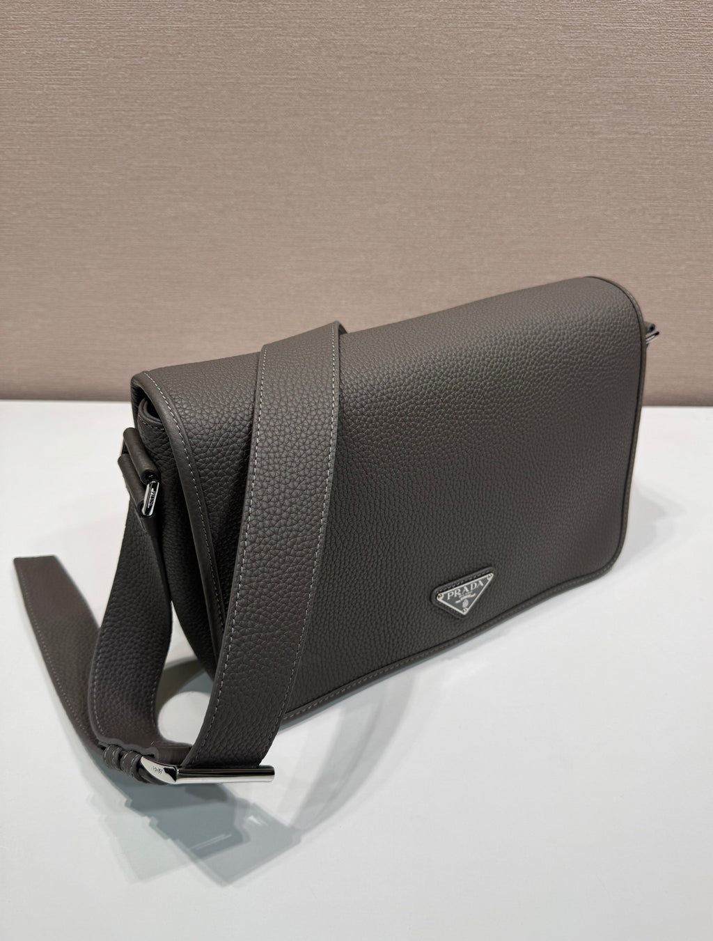 Prada leather crossbody bag with side profile, adjustable strap, and triangular logo