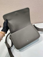 Prada leather crossbody bag open flap showing interior and magnetic closure button