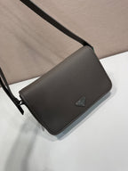 Prada leather crossbody bag with flap and adjustable strap, triangular logo emblem