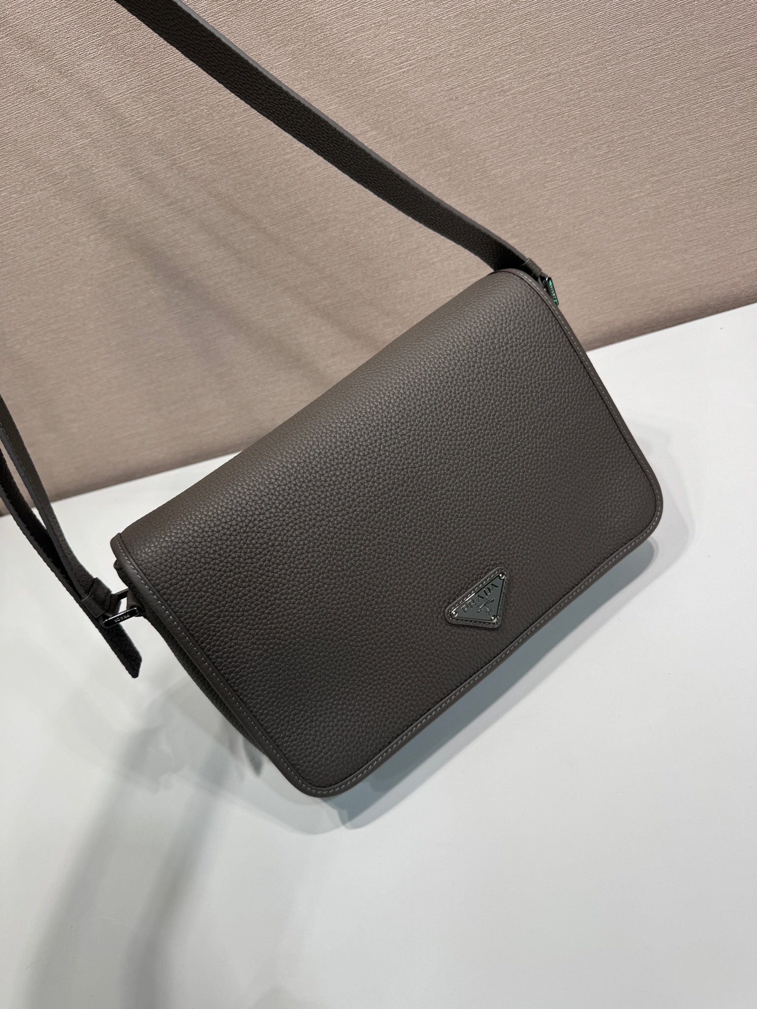 Prada leather crossbody bag with flap and adjustable strap, triangular logo emblem