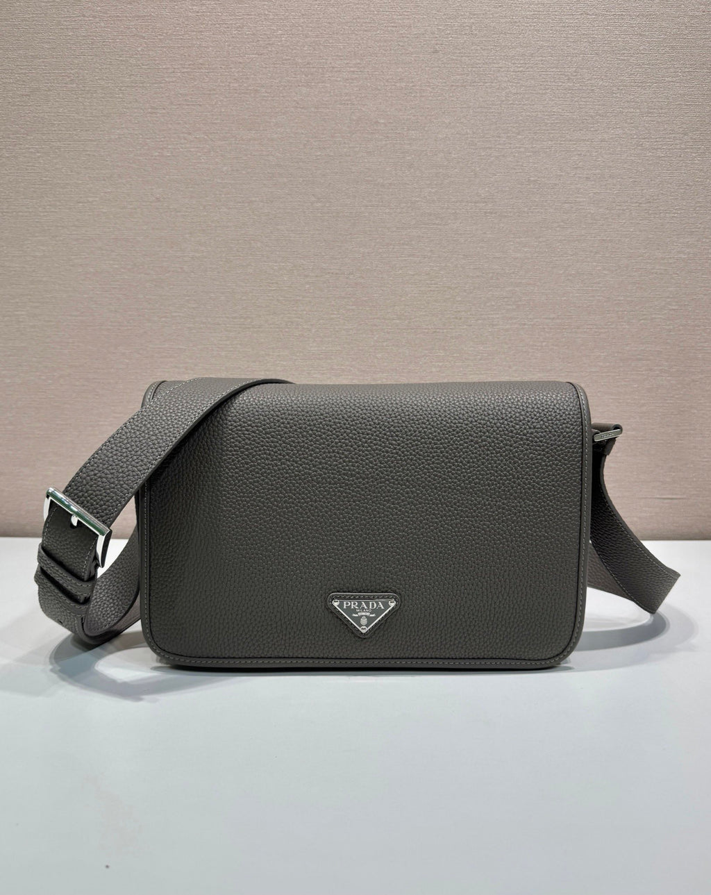 Prada leather crossbody bag with flap, top handle strap, and triangular logo plaque