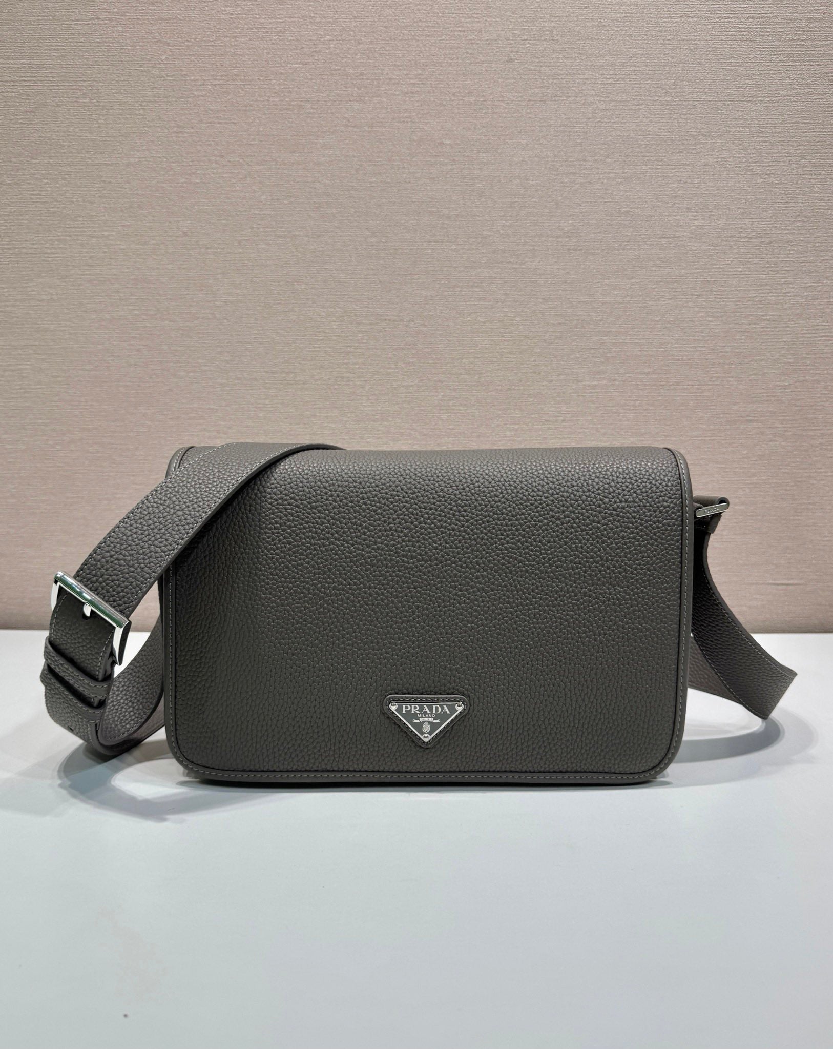 Prada leather crossbody bag with flap, top handle strap, and triangular logo plaque