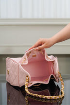 Chanel pink quilted bag opened to reveal interior lining with gold chain strap