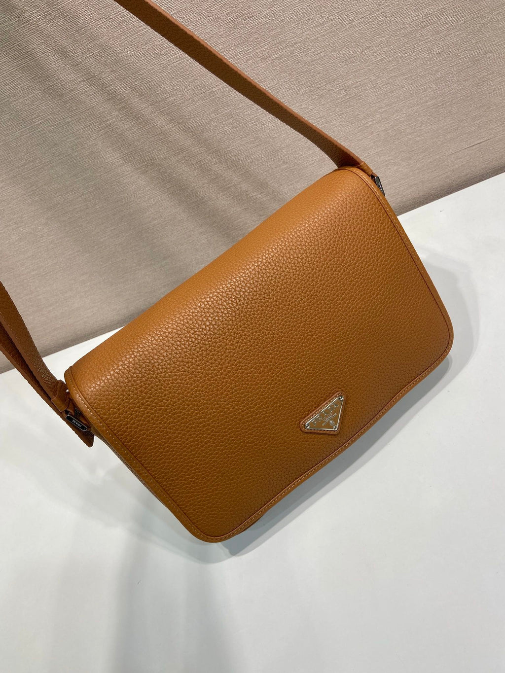 Prada leather crossbody bag, side flap view with triangular logo plaque