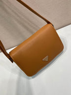 Prada leather crossbody bag, side flap view with triangular logo plaque