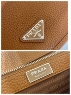 Prada leather bag close-up of logo plate and zipper pull, brown textured leather