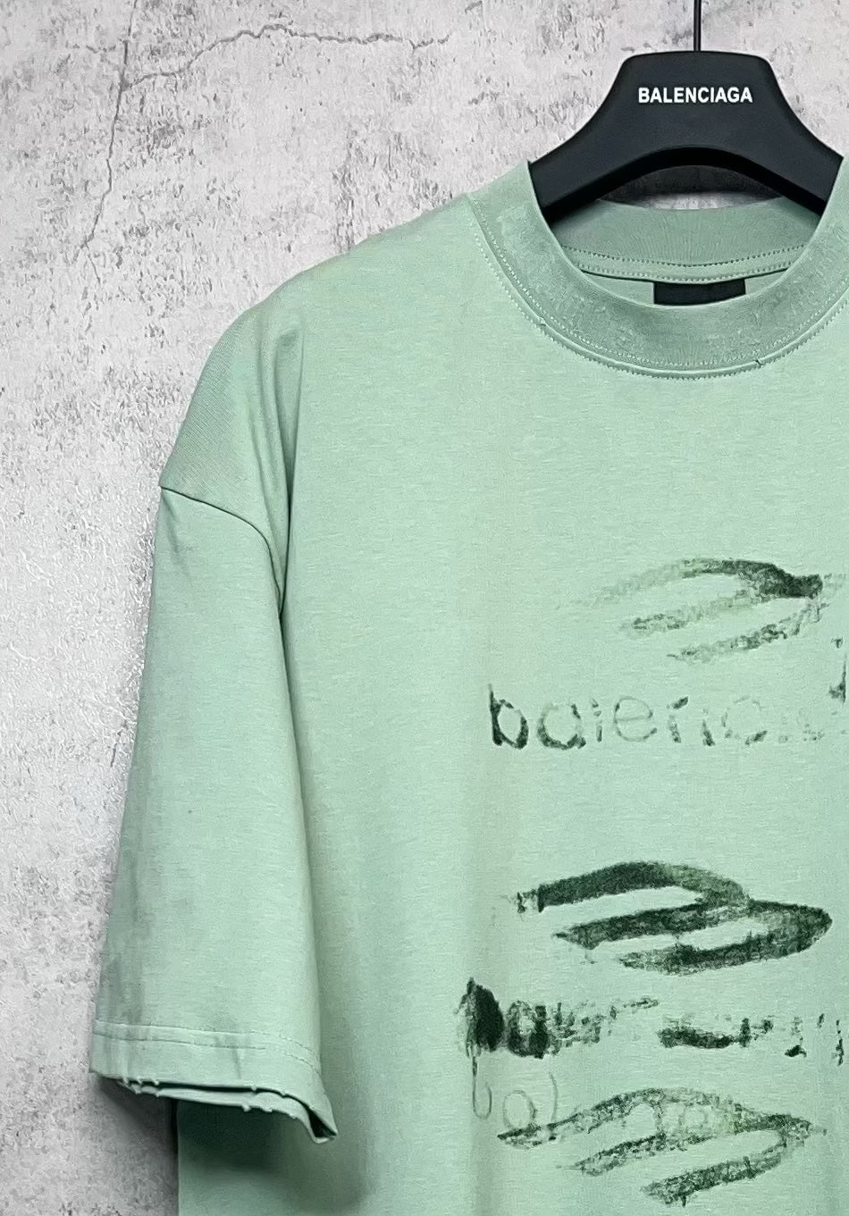 Mint green graphic crew-neck T-shirt with abstract logo print, short sleeves, side seam view.