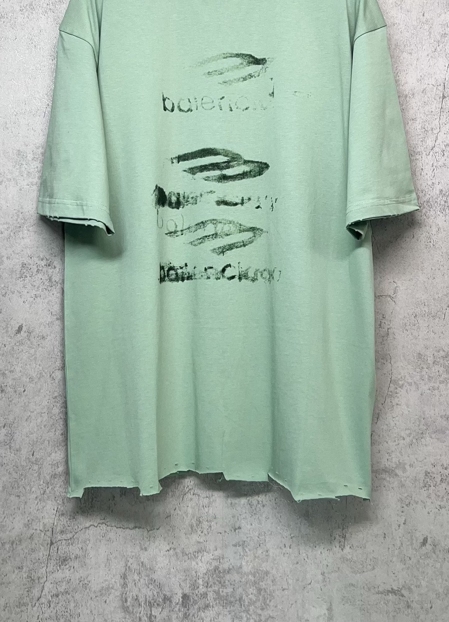 Mint green crew-neck graphic T-shirt with abstract logo print, short sleeves, straight hem.