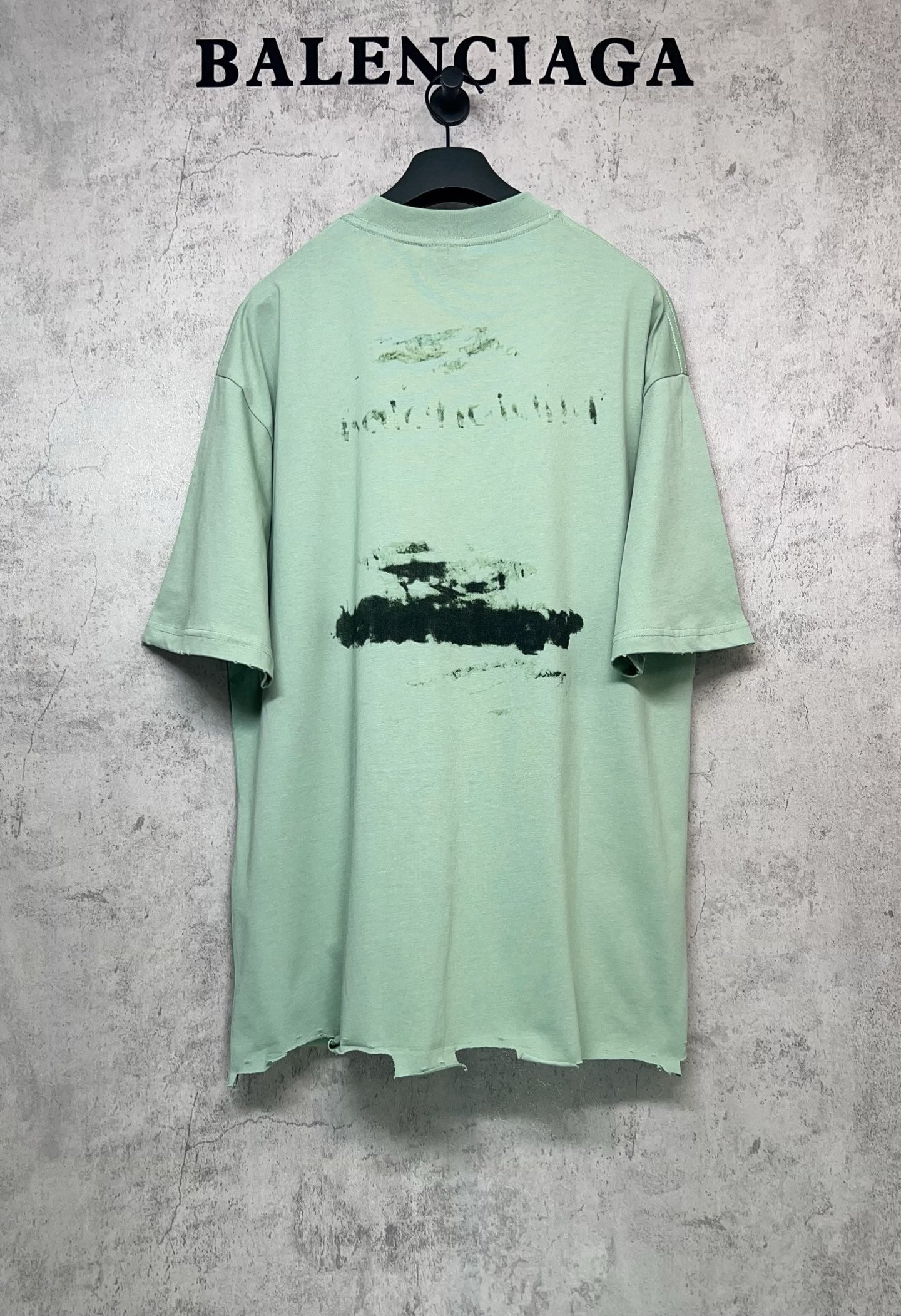 Mint green graphic T-shirt back view, crew neck and short sleeves, abstract print.