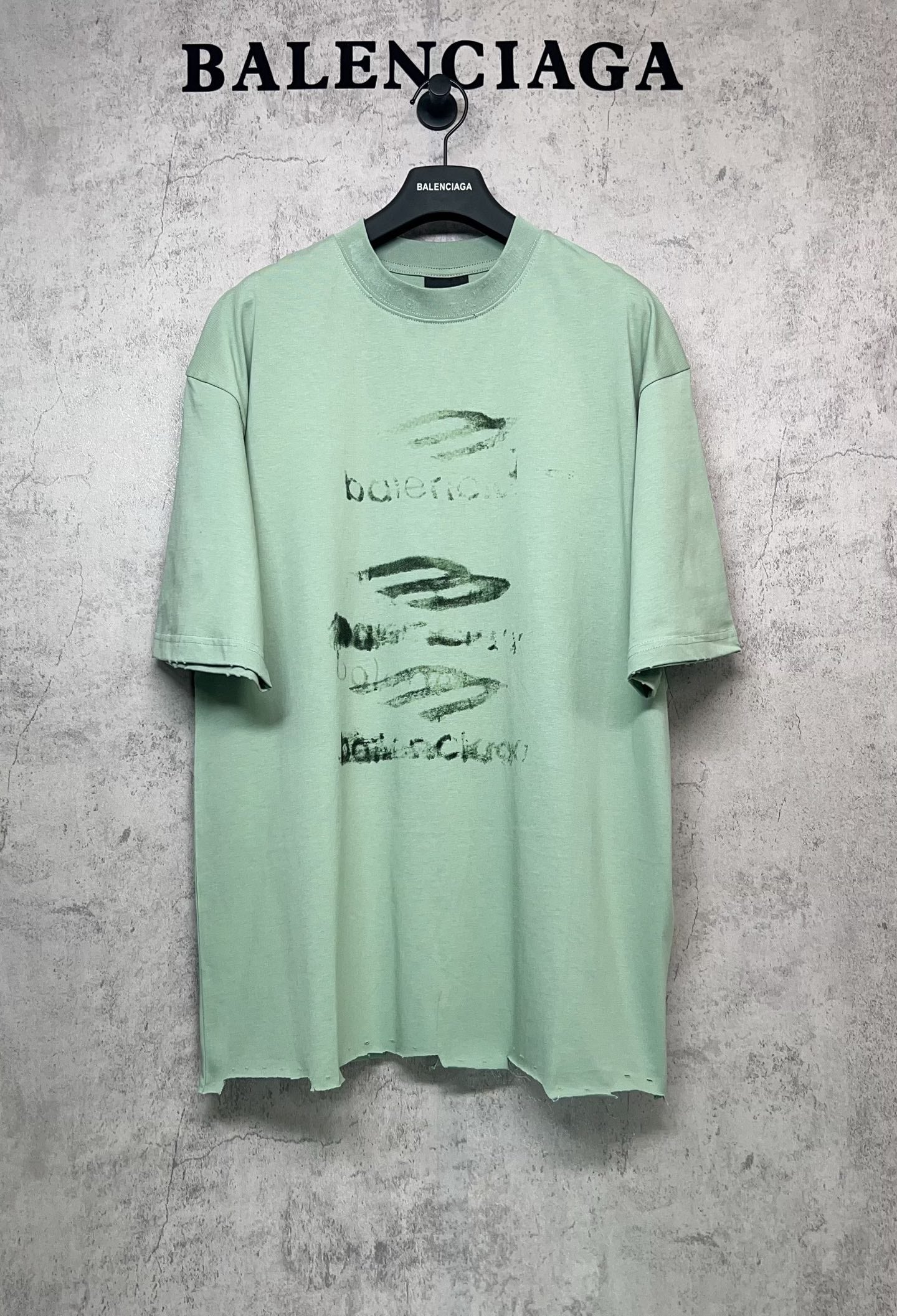 Mint green graphic T-shirt with crew neck and short sleeves, front abstract logo print.