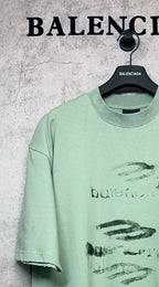 Mint green graphic T-shirt with abstract logo print on front, crew neck, short sleeves.