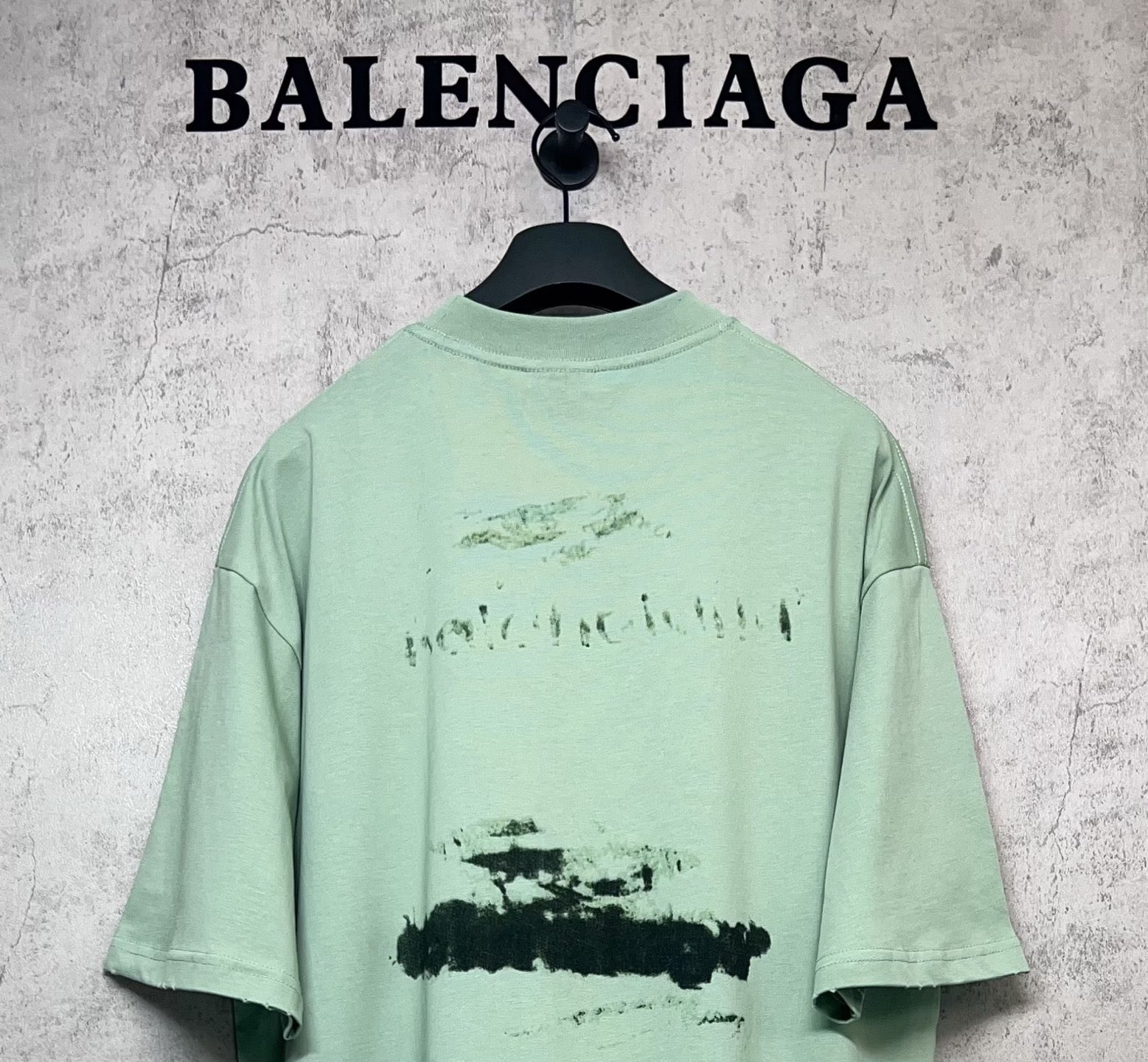 Mint green graphic T-shirt back view with abstract logo print, crew neck, short sleeves.
