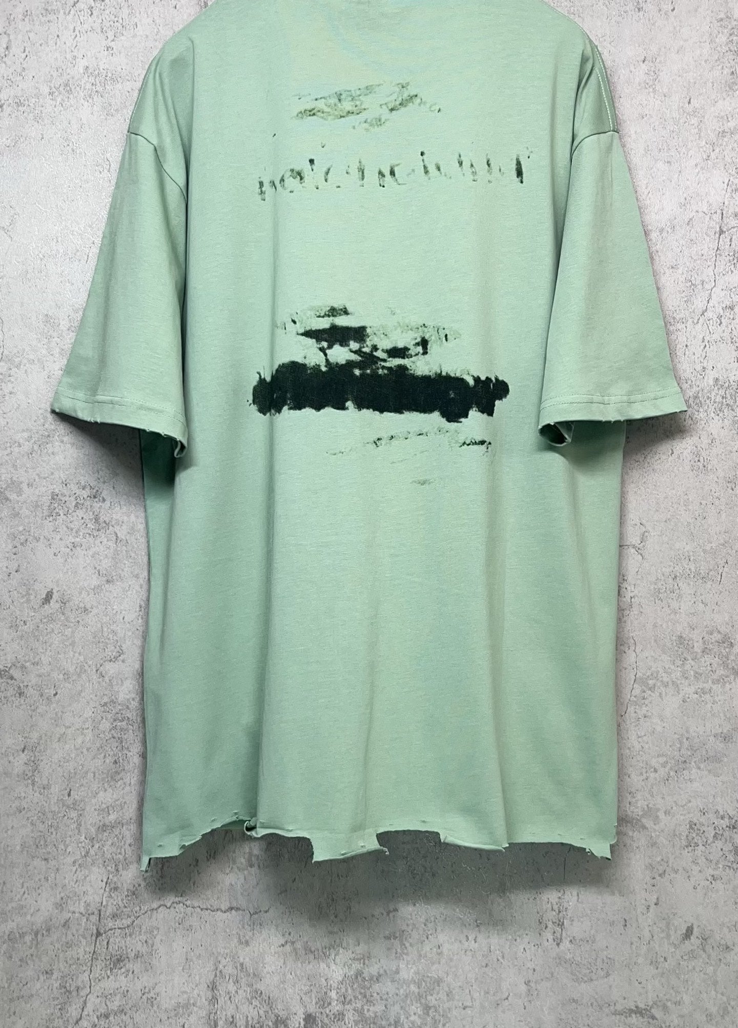 Mint green crew-neck graphic T-shirt back view with abstract logo print, short sleeves.