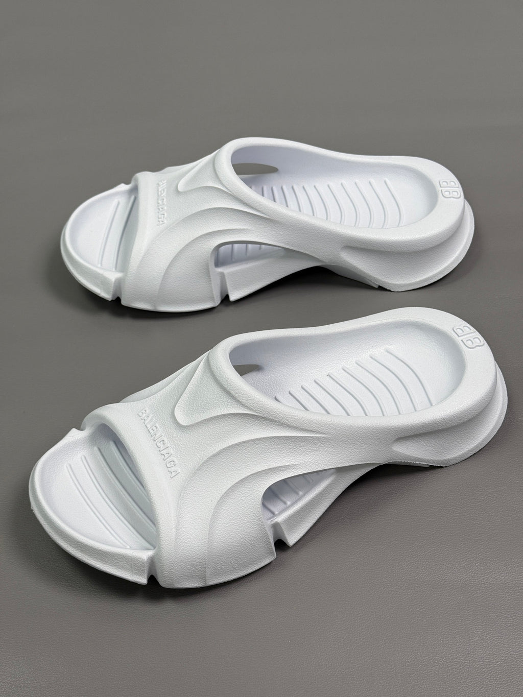 Pair of Balenciaga white slide sandals with cushioned straps and ribbed footbeds