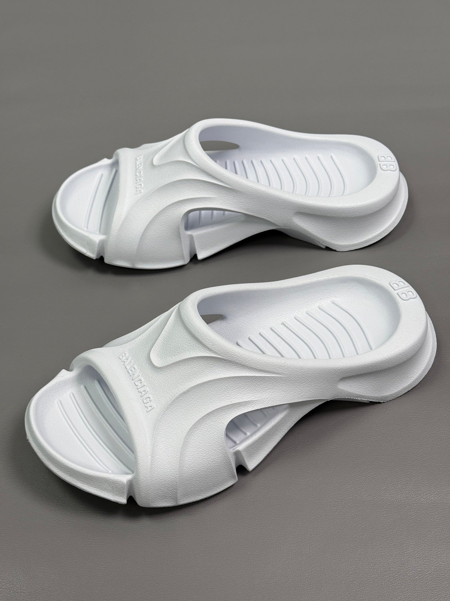 Pair of Balenciaga white slide sandals with cushioned straps and ribbed footbeds