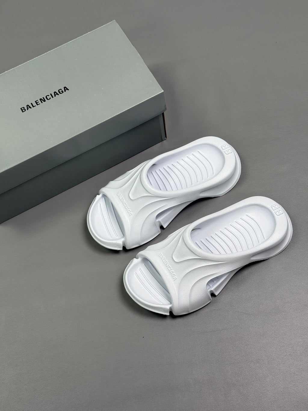Balenciaga white slide sandals with outsoles and box beside them