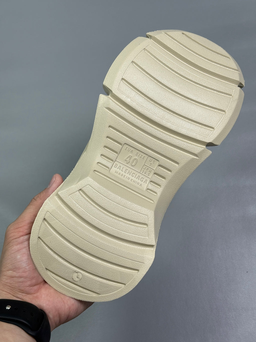 Cream sandal outsole close-up showing molded tread pattern and grip channels