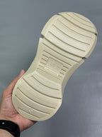 Cream sandal outsole close-up showing molded tread pattern and grip channels