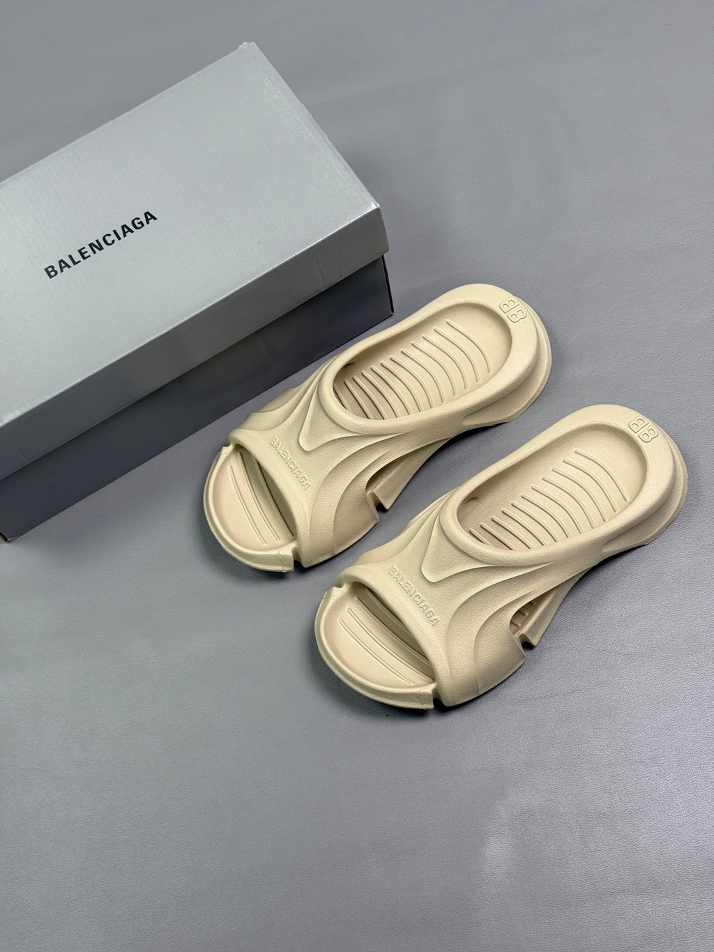 Cream Balenciaga slide sandals with brand box on a flat surface