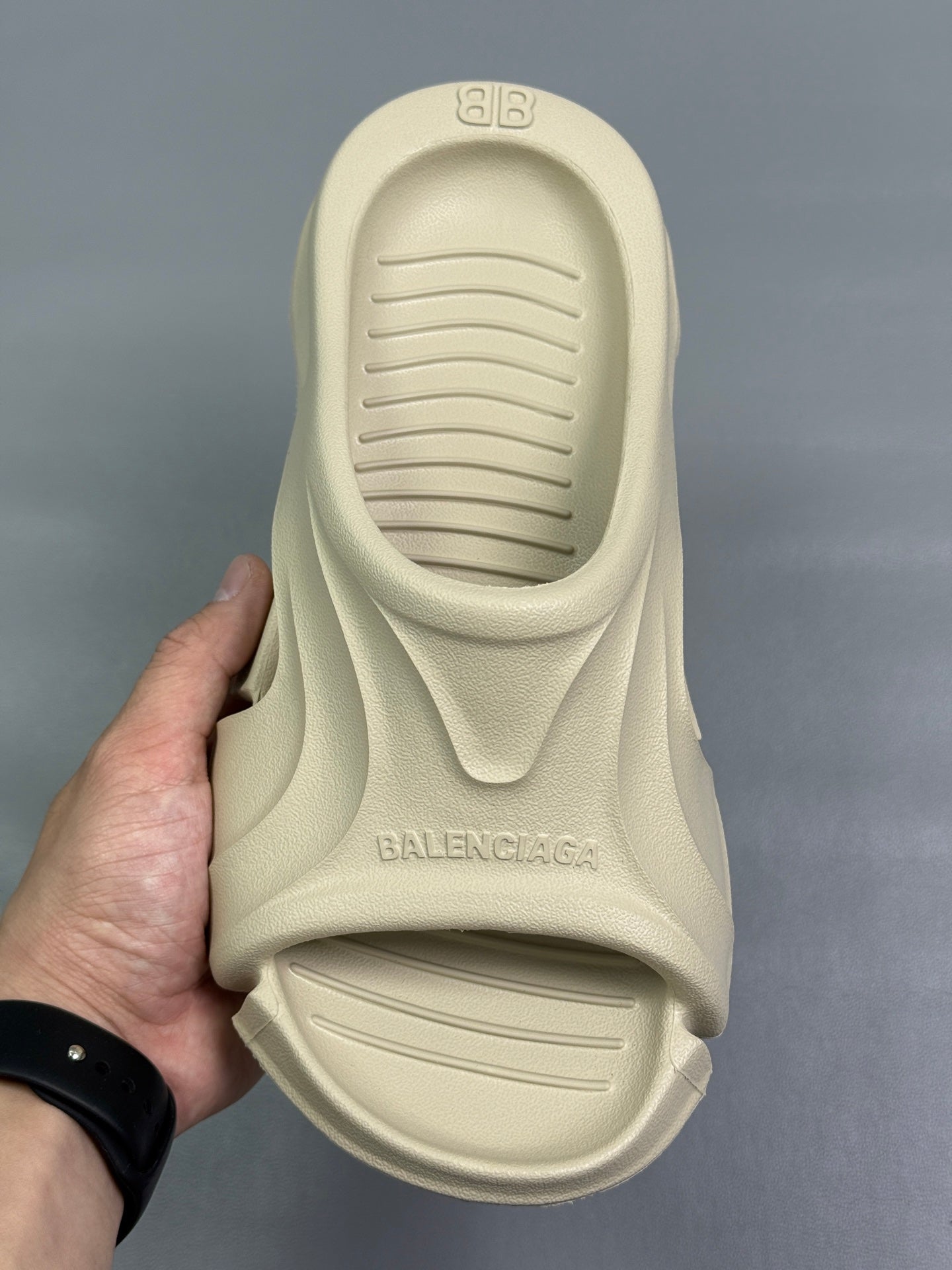 Cream slide sandal heel view with embossed BALENCIAGA logo on footbed