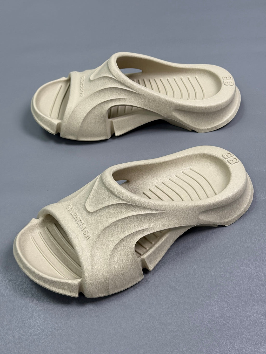 Pair of cream Balenciaga slide sandals with open toe and cushioned footbed