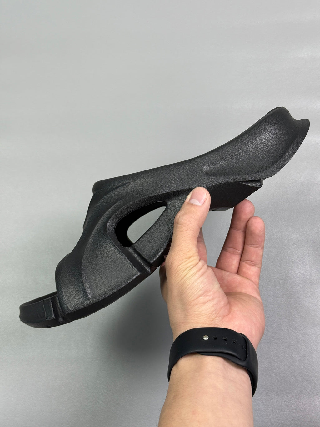 Black slide sandal with curved upper cutout and chunky tread outsole